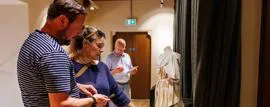 People looking at exhibit inside Maison Dieu