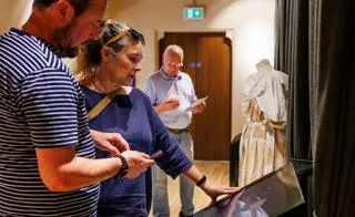 People looking at exhibit inside Maison Dieu